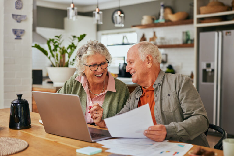 A senior couple sitting in the kitchen putting together an estate plan.